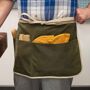 Garrett Wade USA Made Rugged & Versatile Waxed Cotton Apron - Olive We designed and made these versatile and tough mid length aprons exclusively for us in the USA. They will keep you clean and covered in all kinds of situations. Wear in your shop or garden to keep all the tools you need at the ready without the bulk of a full length apron. Made from durable heavy duty waxed canvas, it features 3 front pockets of varying widths for tools, phone, gloves, etc. The pockets are all 8  high and measure 5 ¼ , 7 , and 12  wide. You may also appreciate the extra care we' 