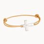 Merci Maman Personalized Flat Cross Bracelet This sleek  gently curved cross bracelet is a classic design.Our cross bracelet can either be part of your stack or a stand alone piece and is slightly curved for comfort. The discreet cross symbol will lie flat upon the wrist with your engraving down the length.Hallmarked 925 sterling silver or 18K Gold Plated0.8 x 0.6Wide choice of colorfast braid coloursAdaptable sizeHand-engraved in our London workshopSent with love in a complimentary gift boxAny slight variations in lettering depth  spacing and alignment from the examples shown are part of the aesthetic and originality of the pieceChildren’s Warning: please note  this piece of jewellery is not a toy. We advise you to not leave your child unattended when wearing their special piece as small and delicate charms can be a choking hazard if ingested. 